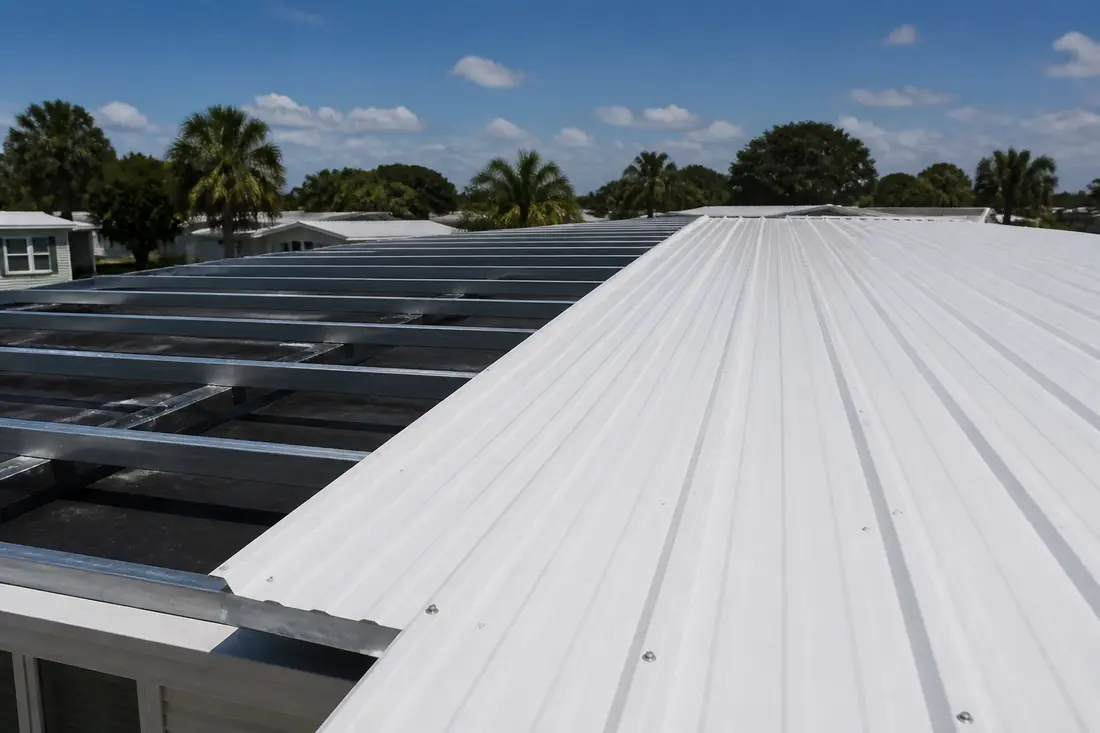 Metal roofing panels being laid over hat channel on a manufactured home