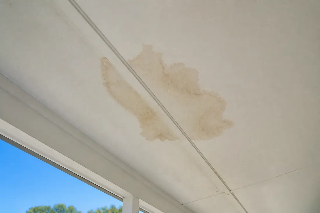 A brown stain spreading across a manufactured home ceiling panel