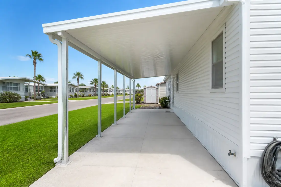 A carport standing on its own posts alongside a manufactured home in Central Florida