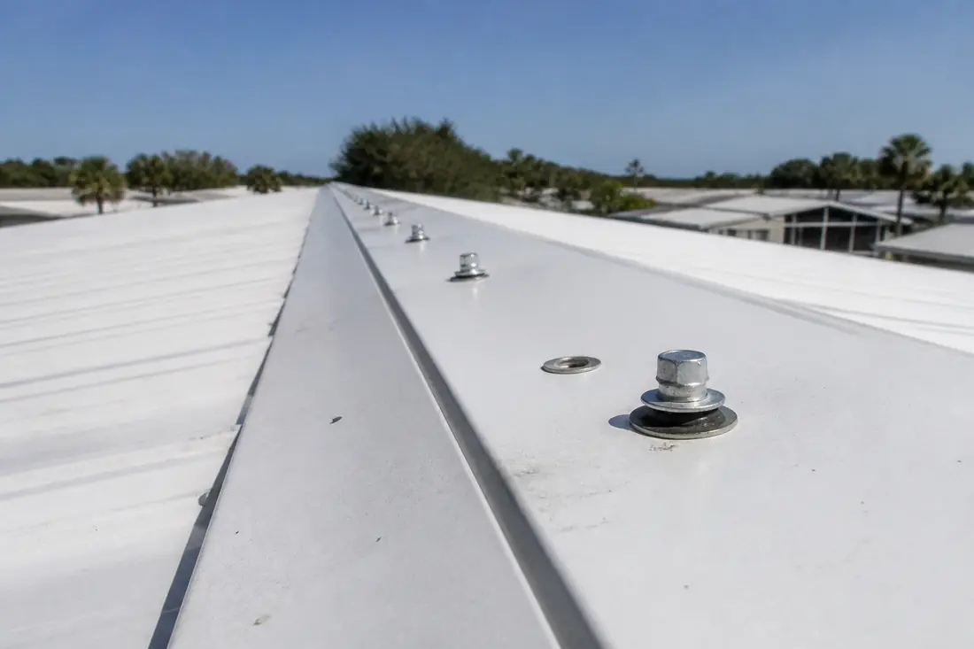The ridge cap and fastener line along the top of a manufactured home metal roof