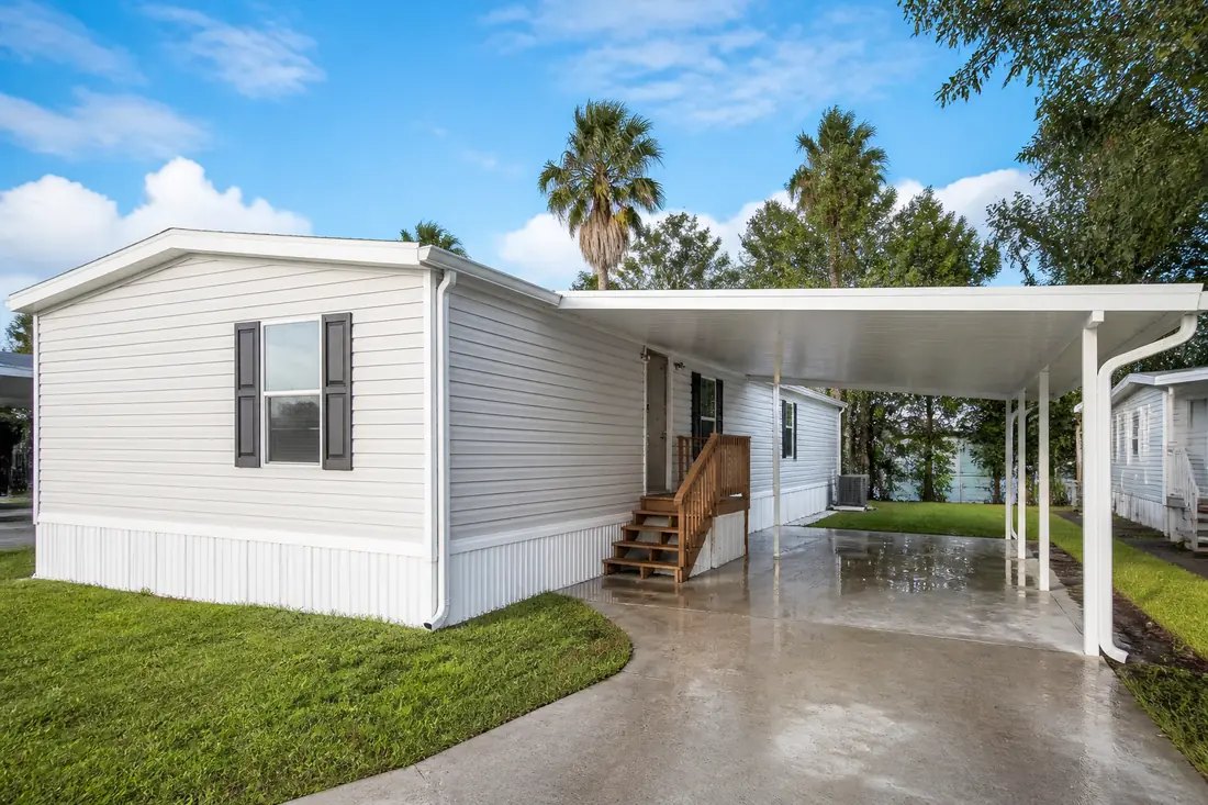 A recently set manufactured home in a Central Florida community after rain, water still standing on the carport slab
