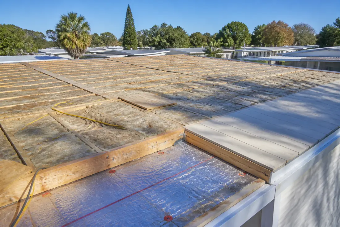 New framing laid across the original low-slope roof of a manufactured home
